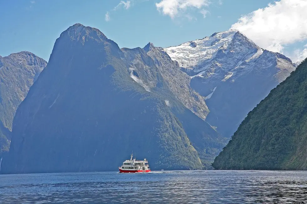 A cruise boat below the fiord wall, for scale